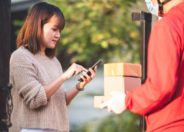 young-women-sign-pick-up-goods-through-smart-phone-courier-service-concept